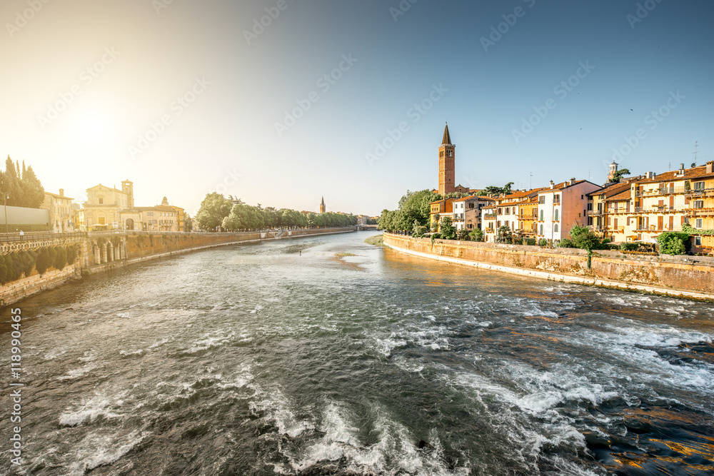 Verona cityscape view on the riverside with historical buildings and tower on the sunrise