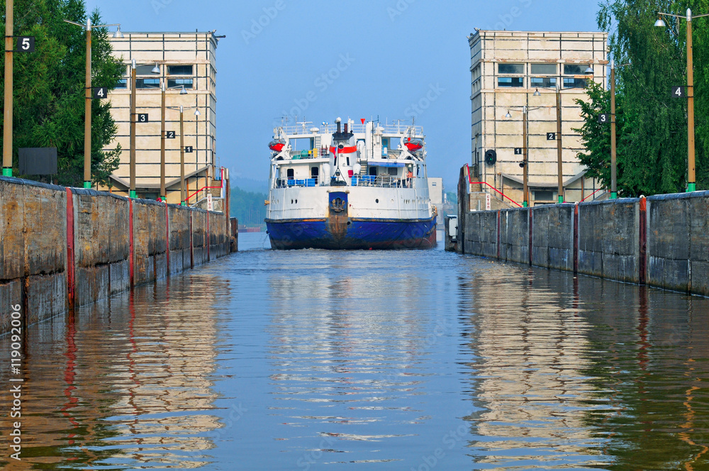 The ship passing through a lock on the river.