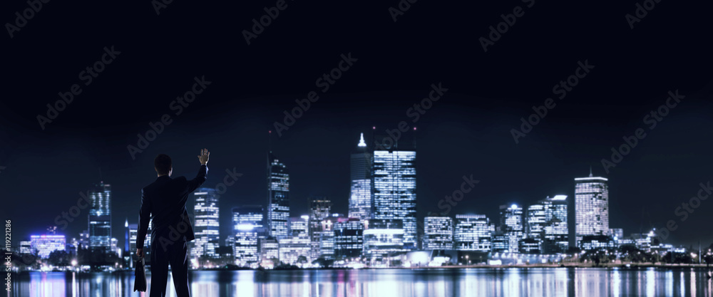 Businessman viewing night glowing city