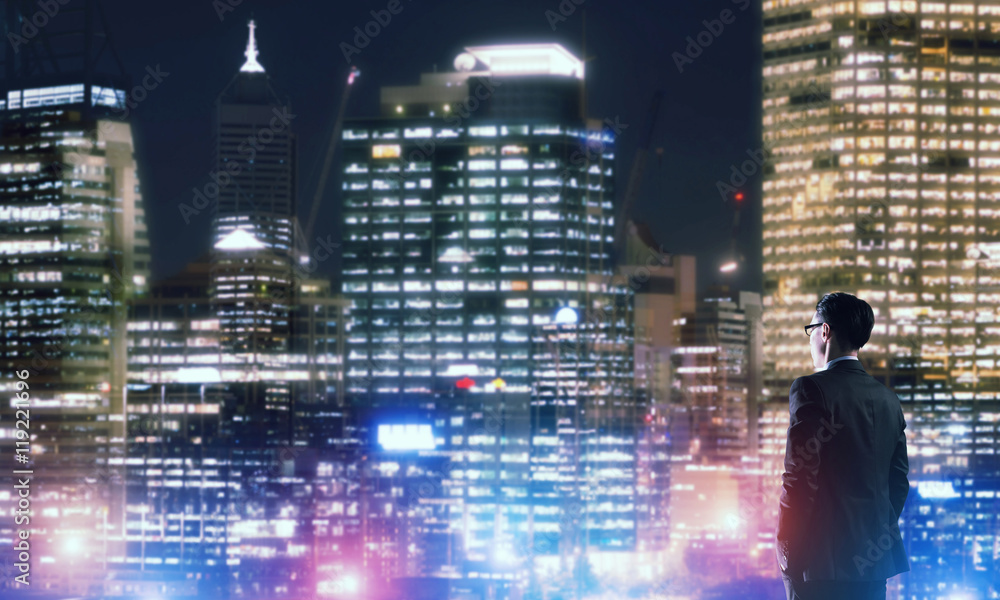 Businessman viewing night glowing city