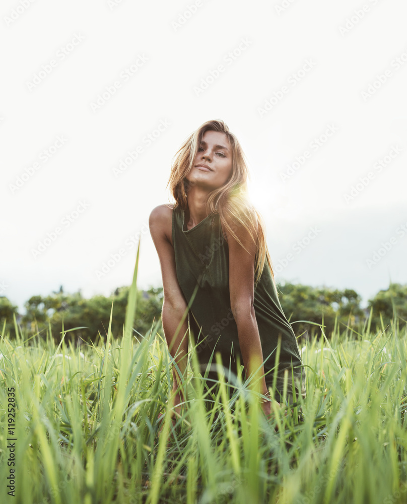 Attractive young lady sitting in the field