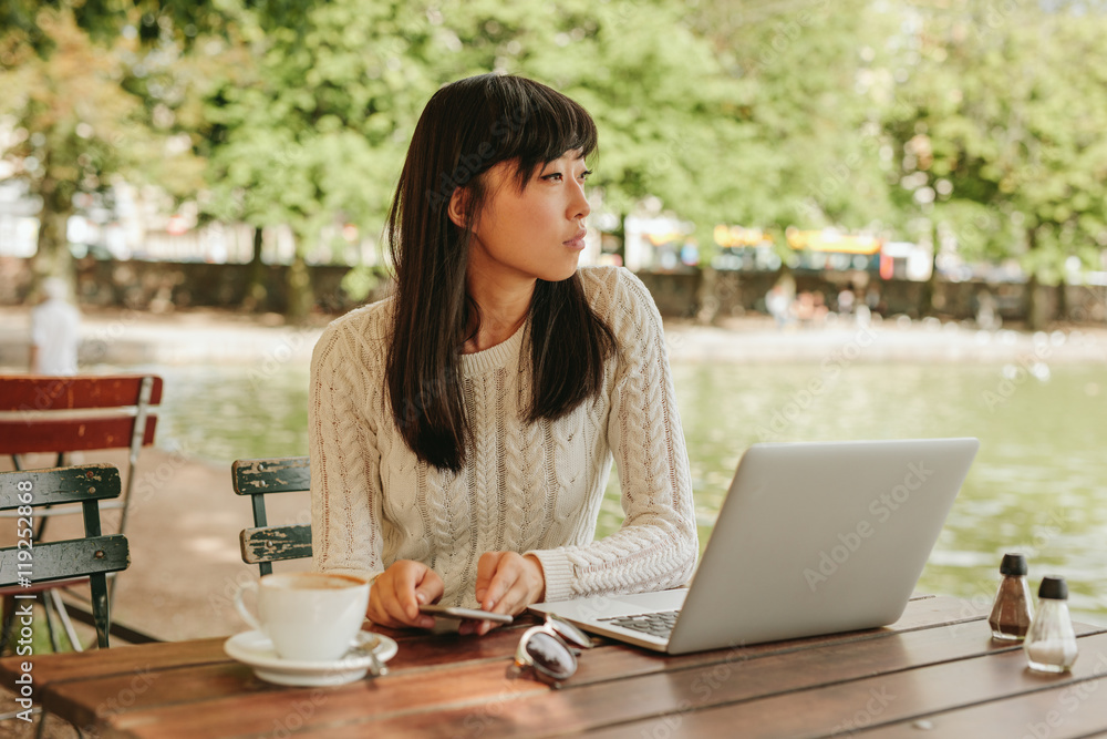 Young woman relaxing at outdoor coffee shop