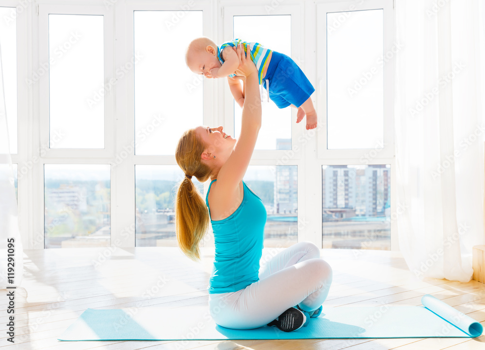 sports mother is engaged in fitness and yoga with baby at home