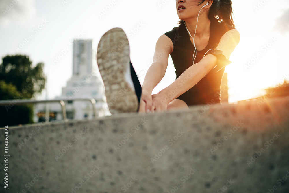 女跑步者晨跑前热身