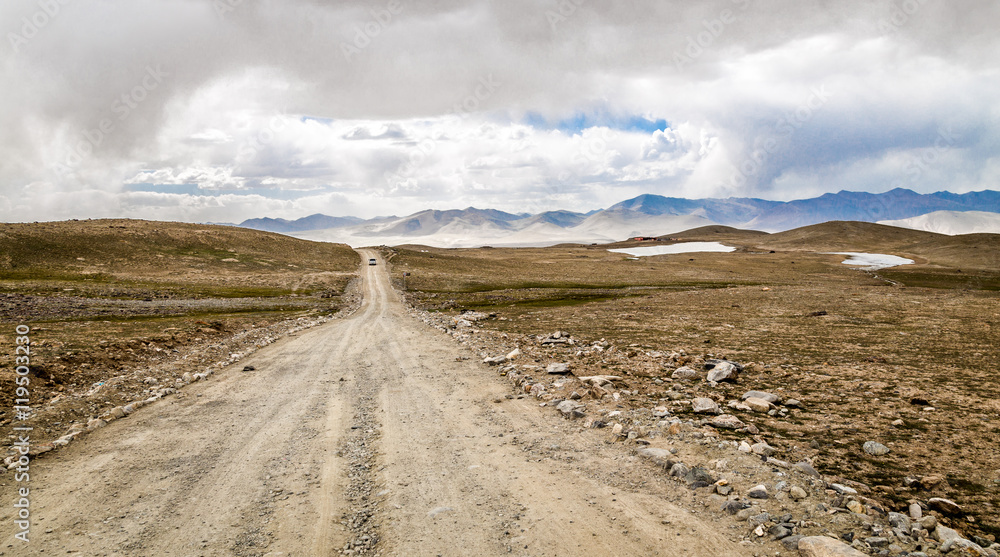 The gravel road leading to the distance.