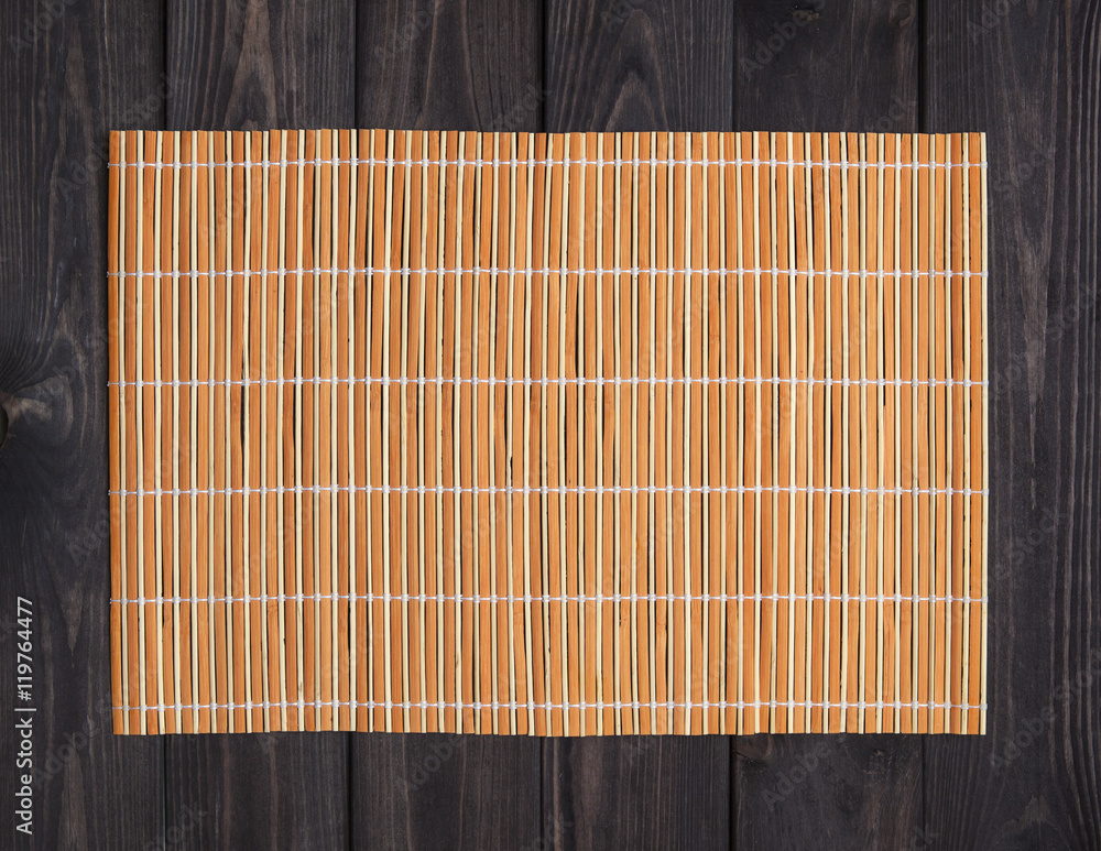 Bamboo mat on wooden table, top view