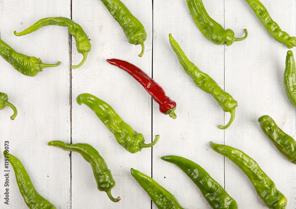 Leadership concept - red hot chili pepper leading the group of green ones