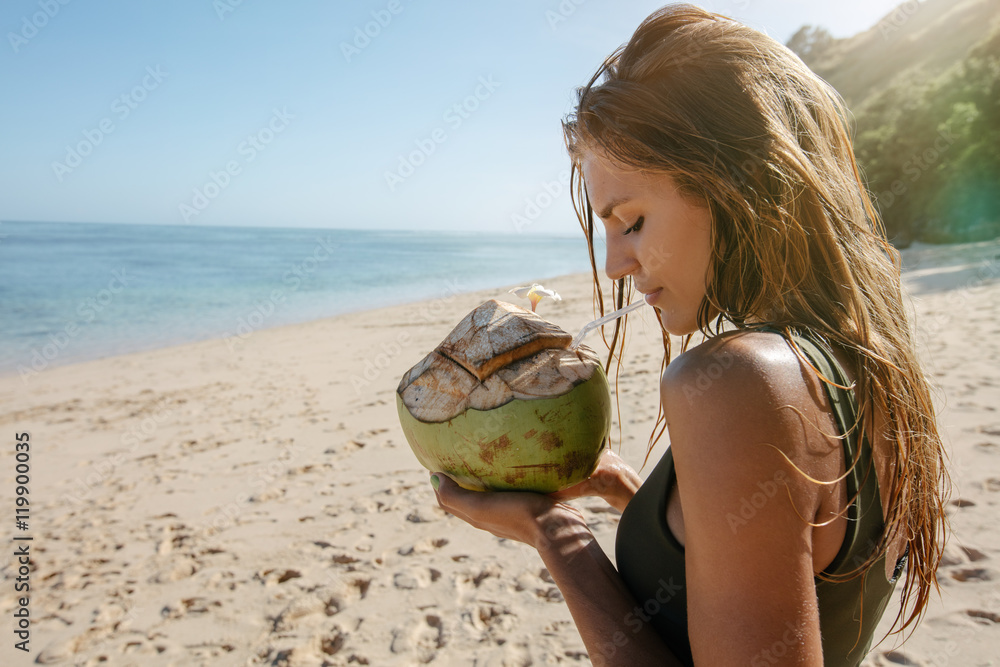 带着椰子去海滩度假的女性游客