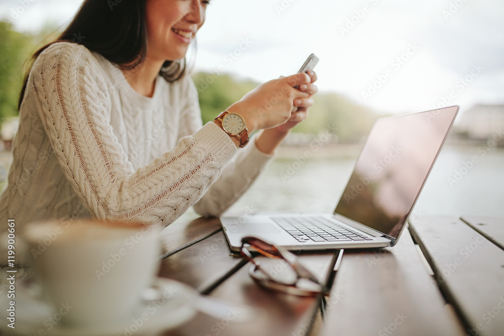 年轻女子在户外咖啡馆使用手机