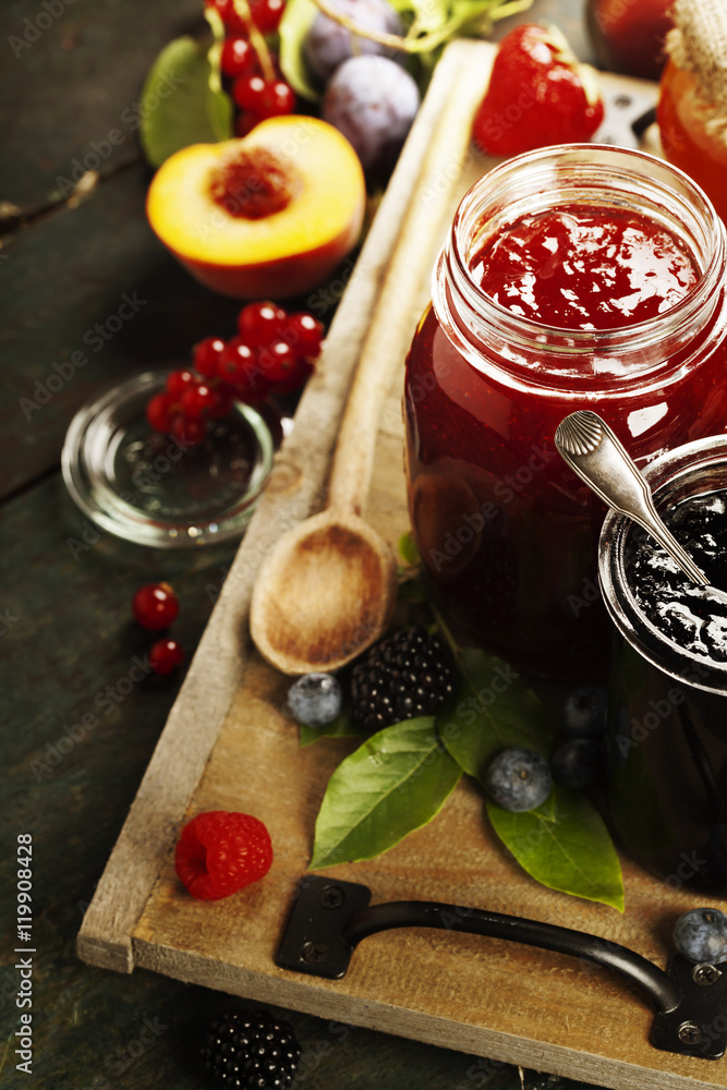 Fruit and berry jam on a wooden background