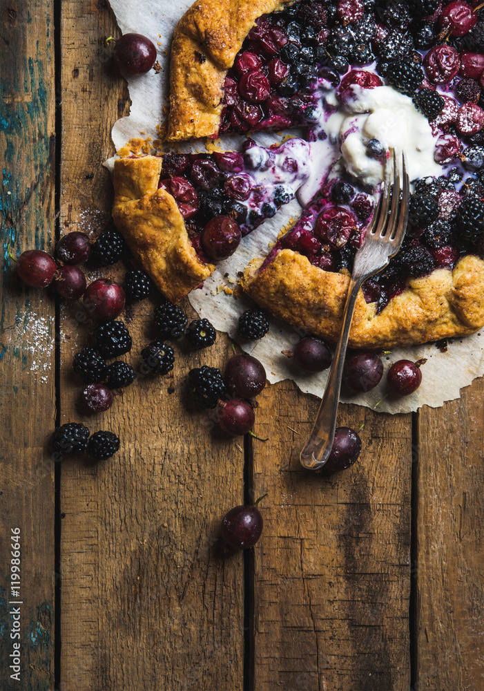 Homemade garden berry galetta or crostata sweet pie with melted vanilla ice-cream scoop served with 