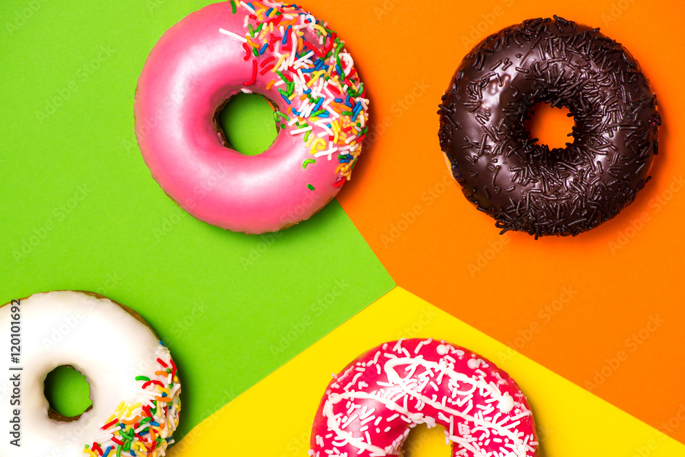 Donuts with icing on colorblock background. Sweet donuts.