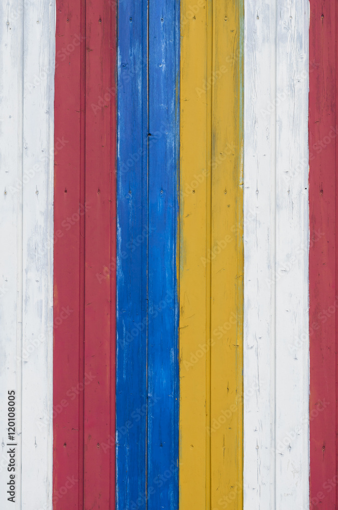 Bunter Holz Hintergrund / Hintergrund aus einer bunten Holzwand gestreift weiss, gelb, blau, rot.