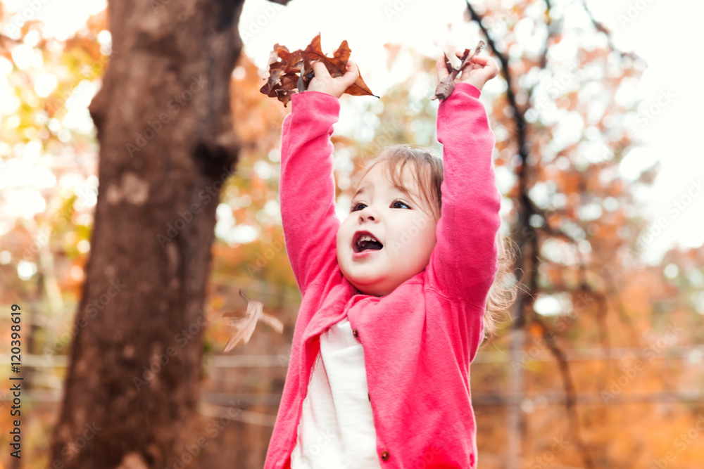 Happy Toddler girl playing outside in autumn