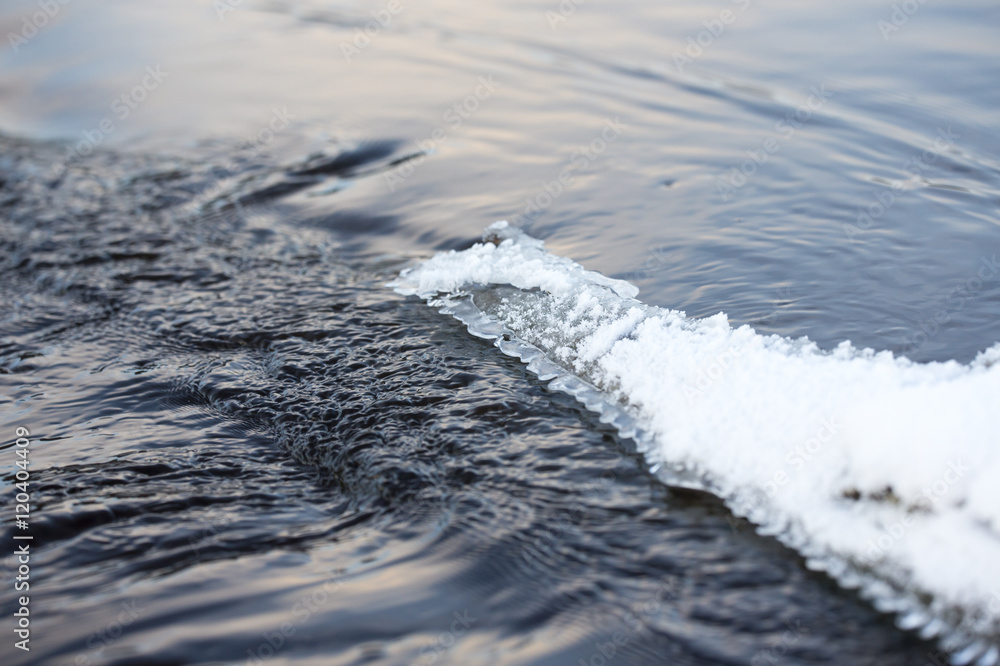 Ice on the water. Some snow is on the ice blocks.