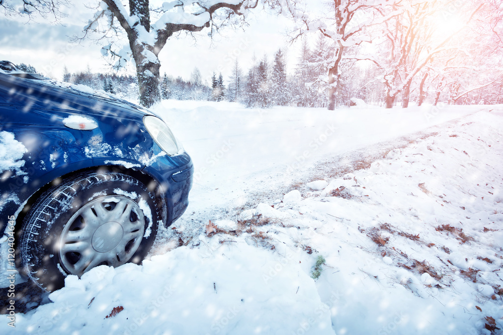 冬季道路上的汽车轮胎被雪覆盖。早上下雪时，车辆在雪地小巷上行驶