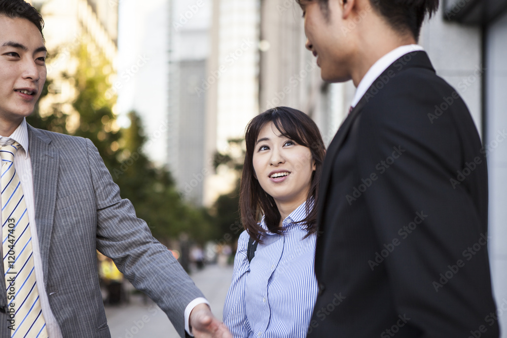 三位年轻的商人，正在办公区交谈