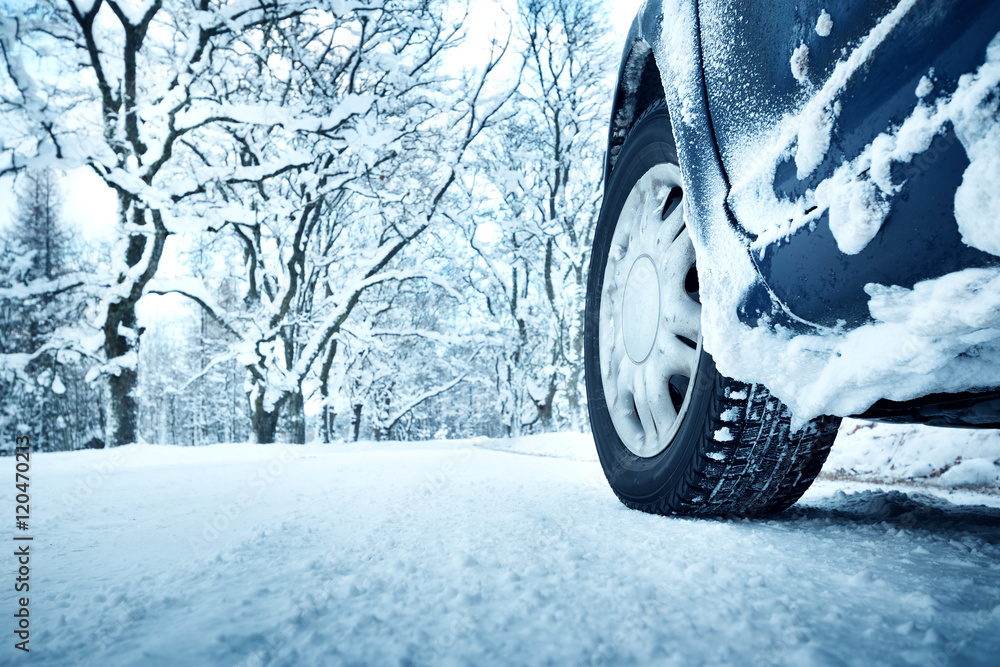 汽车轮胎在被雪覆盖的冬季道路上行驶