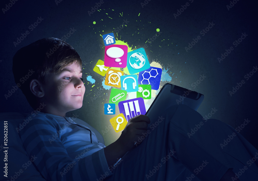 Boy with tablet in his bed