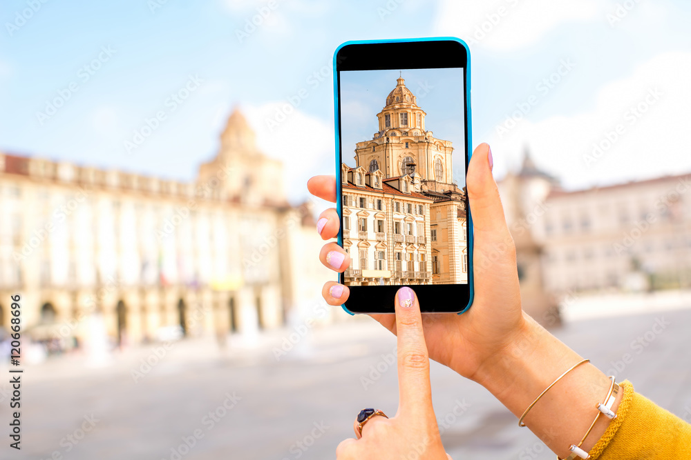 Holding a smart phone with photo of saint Lawrence church on the central square in Turin in Piedmont