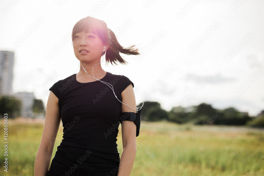 穿着运动服的年轻女子站在城市公园的户外