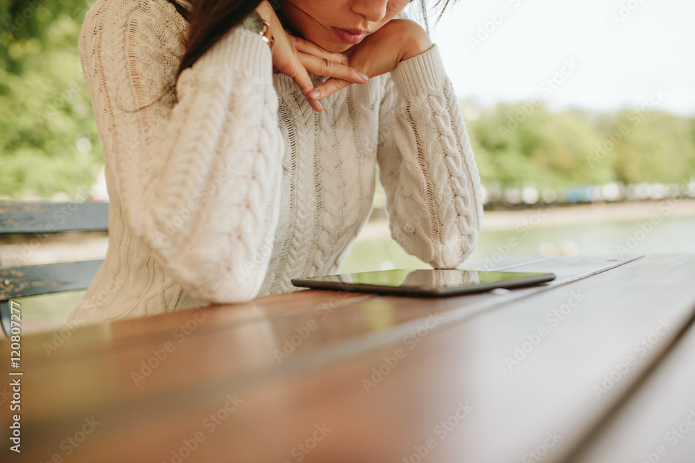 女性在户外咖啡馆阅读电子书