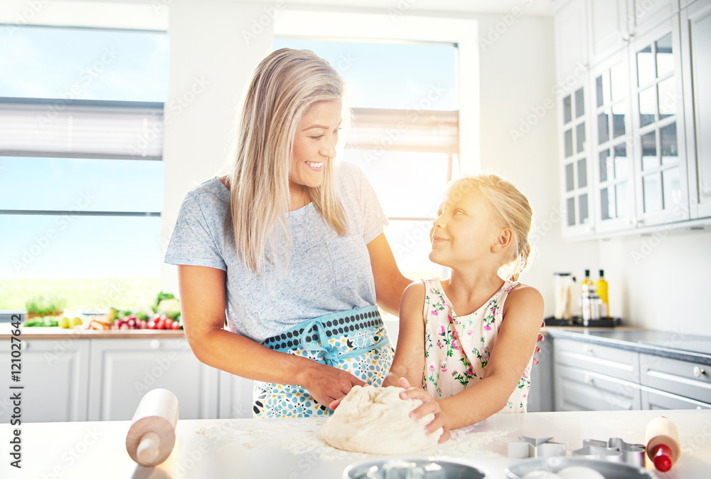 Happy young mother and daughter baking