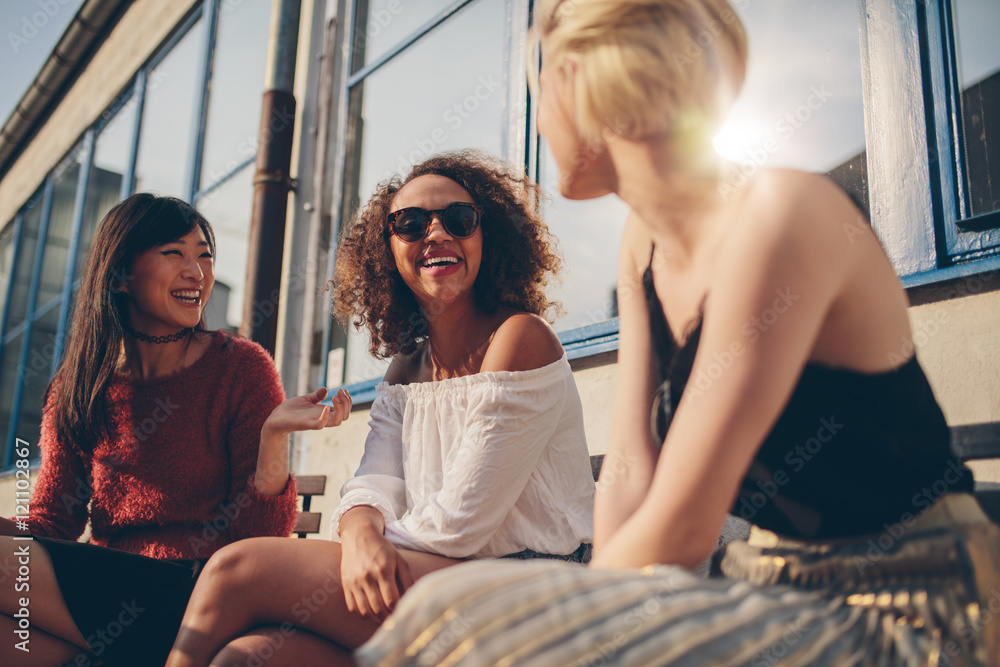 三位年轻女性在户外咖啡馆聚会