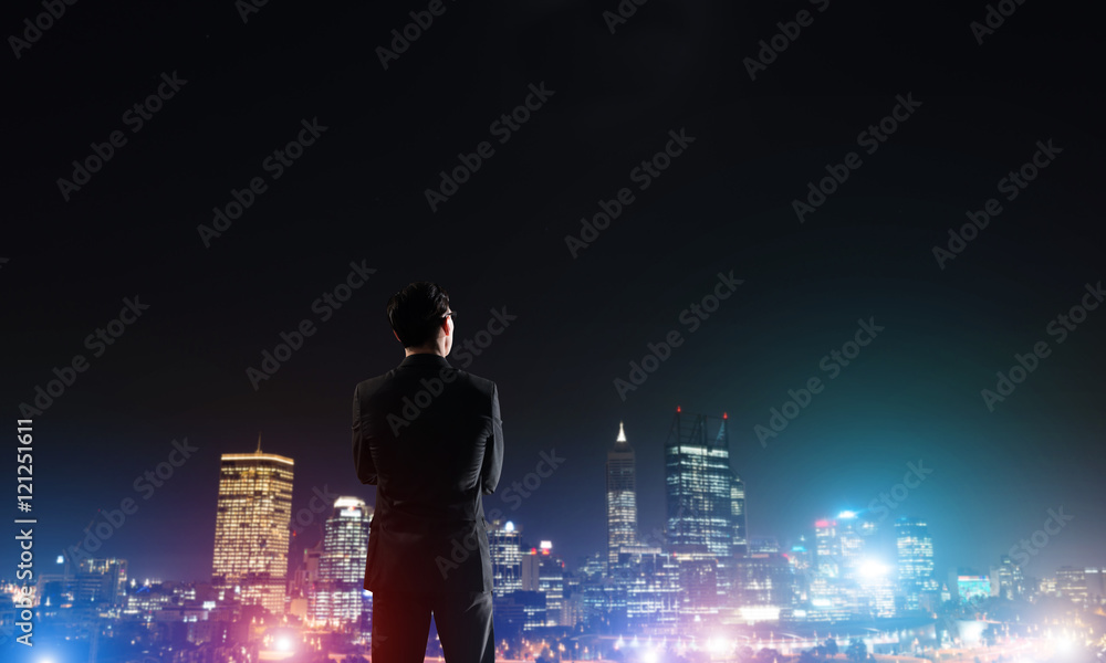 Businessman viewing night glowing city