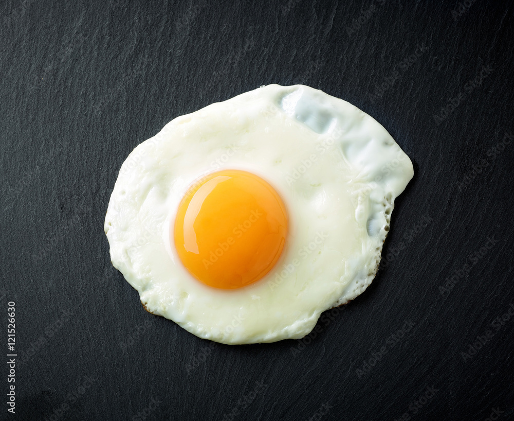 fried egg on black background