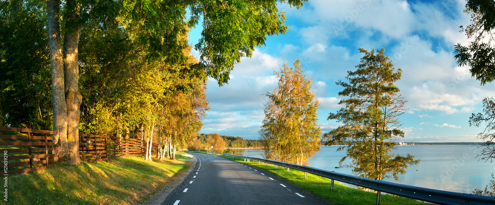 asphalt road at seaside at sunset in autumn