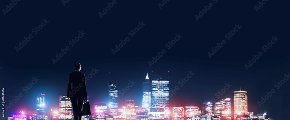 Businesswoman viewing night glowing city