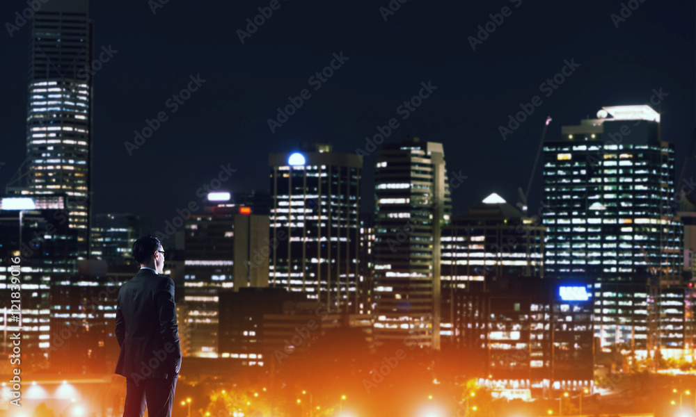 Businessman viewing night glowing city