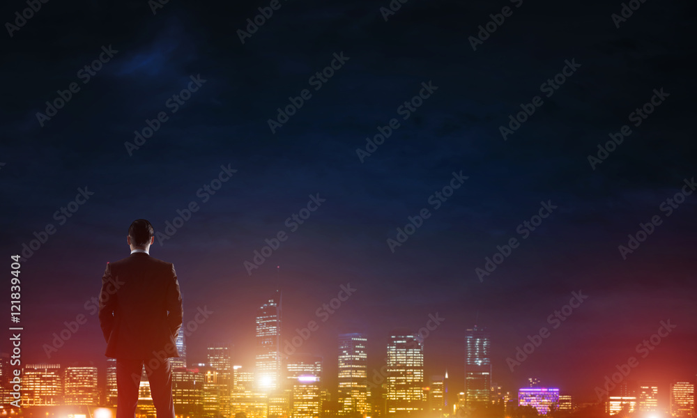 Businessman viewing night glowing city