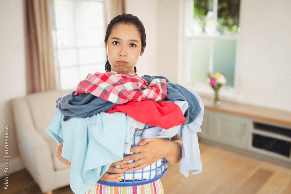 疲惫的女人拿着装满的洗衣篮的合成图像