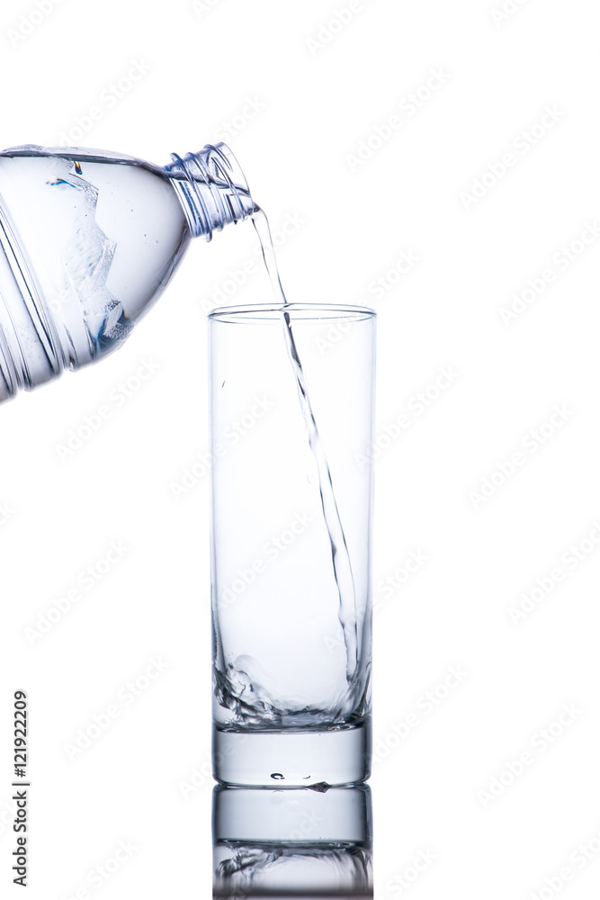 Drinking water is poured into a glass from bottle