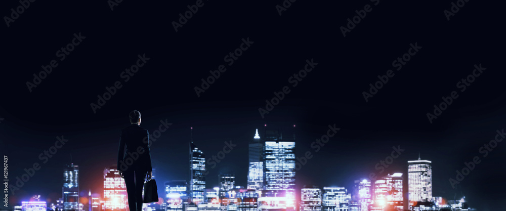 Businesswoman viewing night glowing city