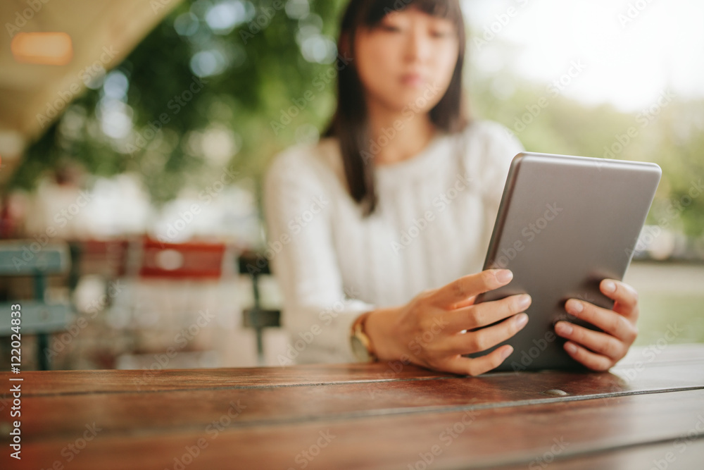 Female using digital tablet at outdoor cafe