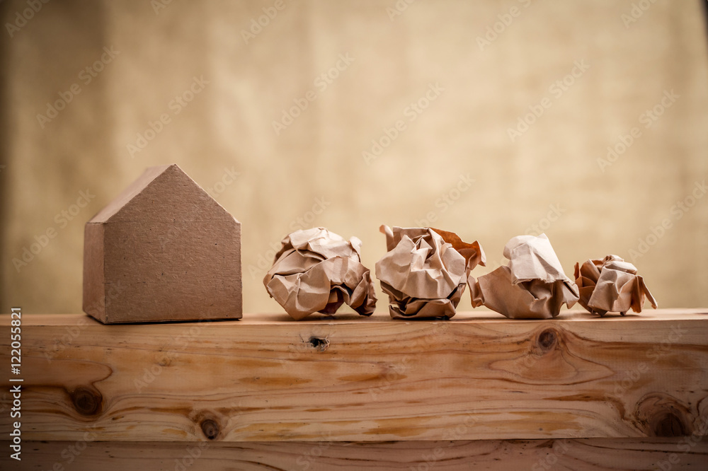 model of paper house building with trash paper balls