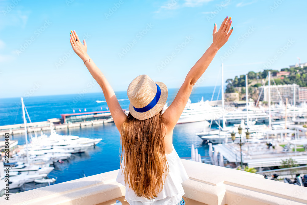 Young female traveler enjoying great view on the harbor with yachts in Monte Carlo in Monaco