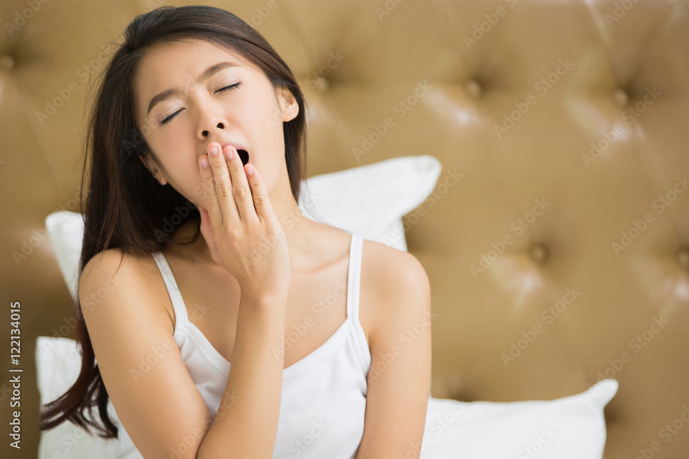 Asian women are yawning after she wake up.