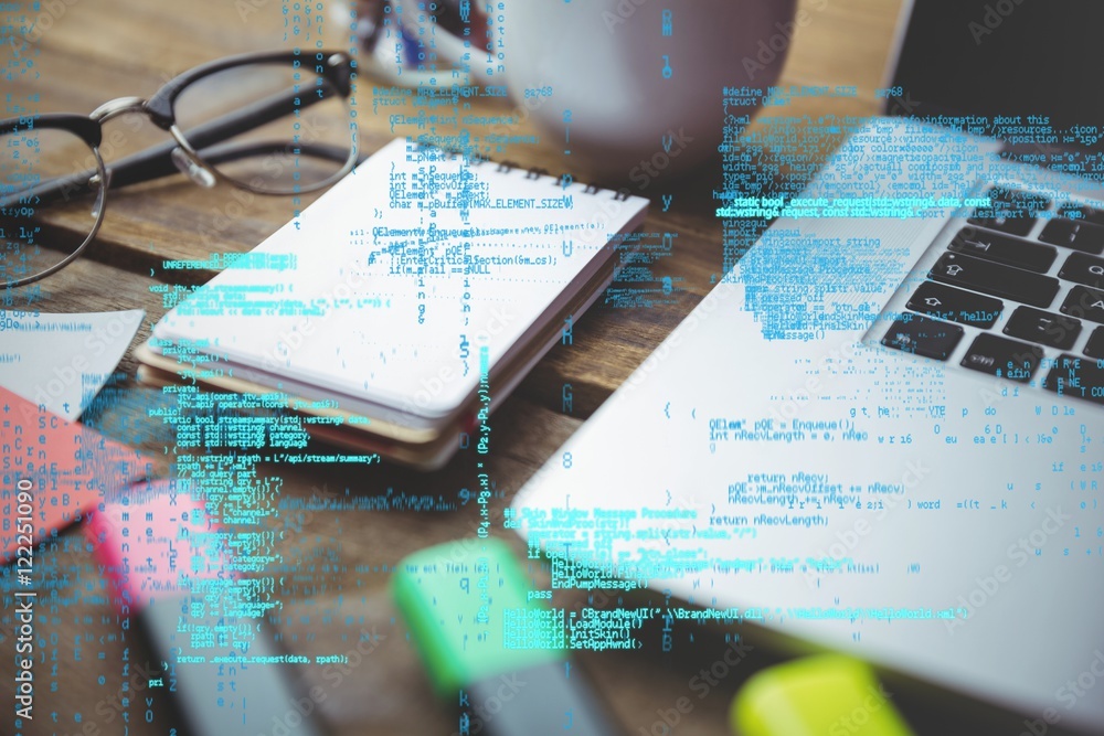 laptop with notepad and coffee on table with graphics