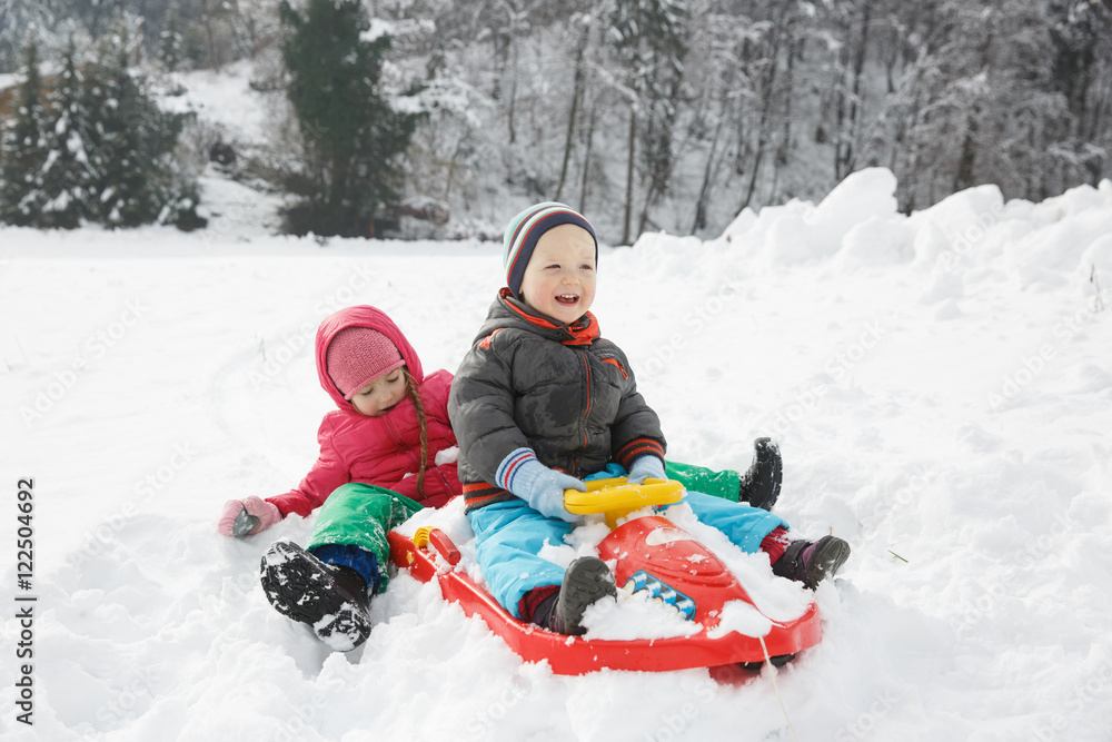 兄弟姐妹在雪地里玩雪橇