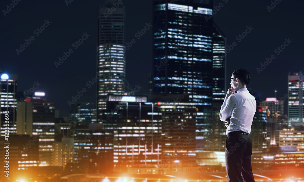 Businessman viewing night glowing city