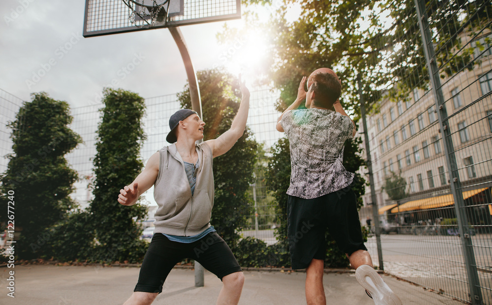 Teenage friends playing a game of basketball