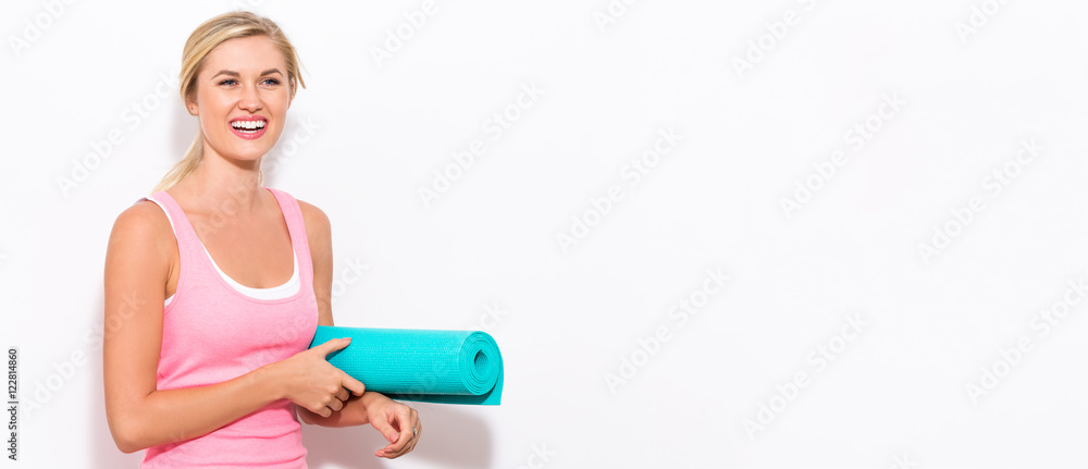 Happy young woman with a yoga mat