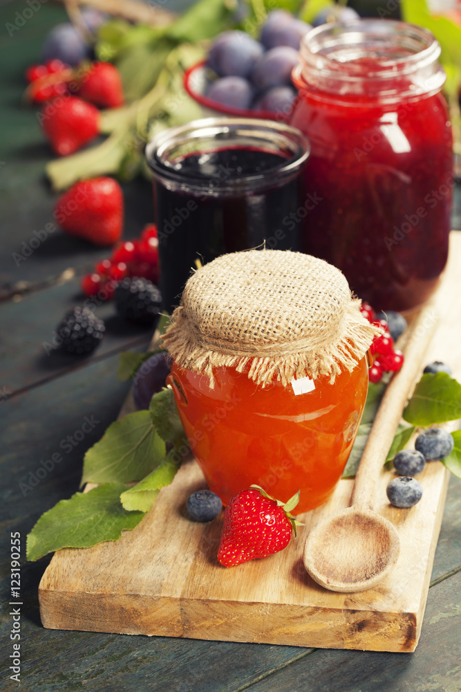 Fruit and berry jam on a wooden background