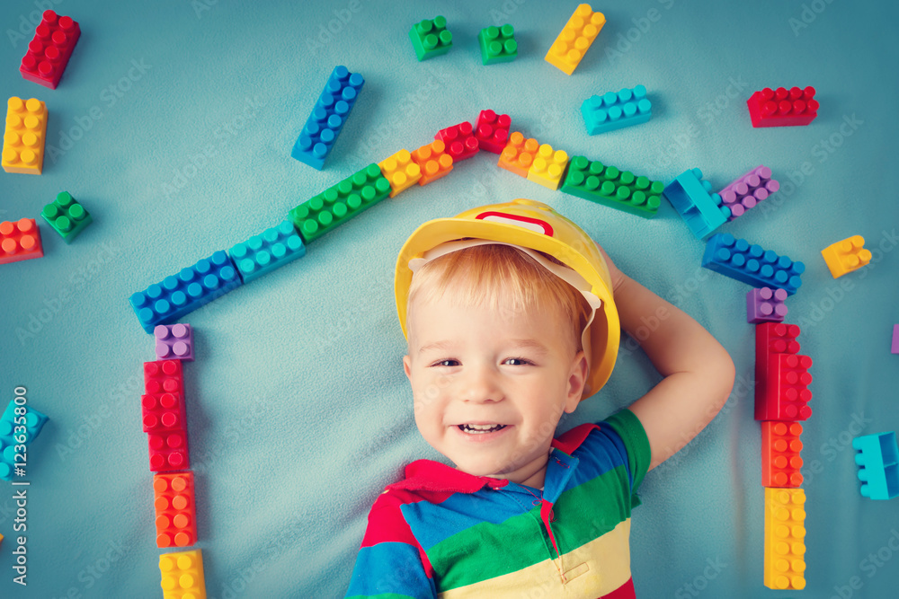 boy lying on the blanket with blocks in house shape