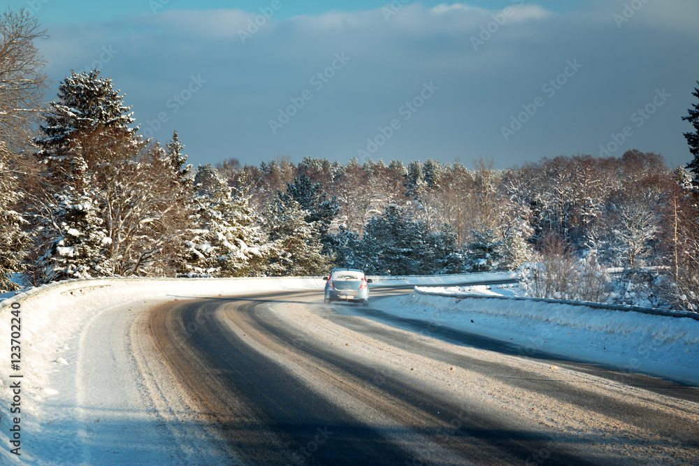 汽车轮胎在被雪覆盖的冬季道路上行驶