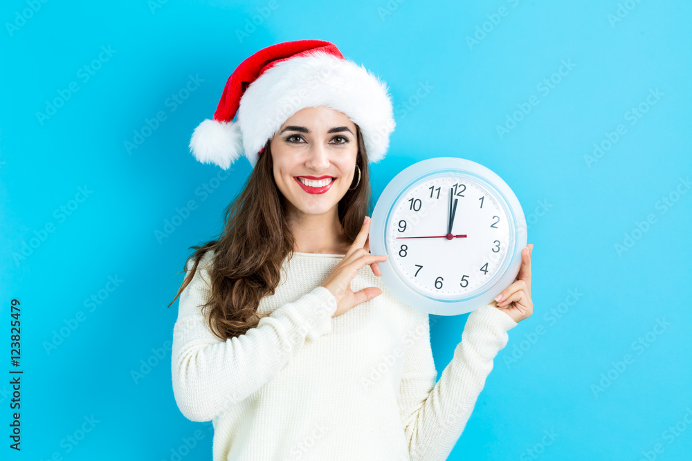 Woman holding clock showing nearly 12